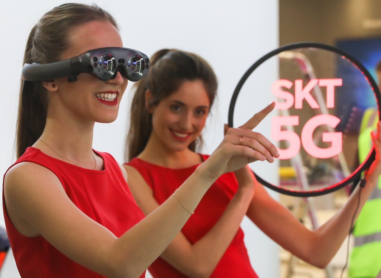 SK텔레콤 모델이 차세대 AR 글래스를 착용하고 5G 기술을 이용한 AR/VR 솔루션 'T 리얼'을 체험하고 있다. / 사진=SK텔레콤