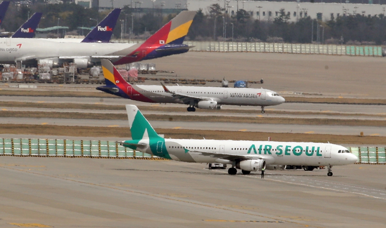 16일 오후 인천국제공항 활주로에 아시아나항공과 에어서울 여객기가 세워져 있다. / 사진=연합뉴스