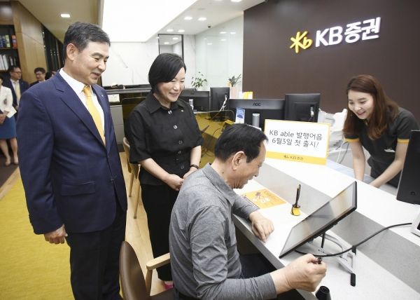 27일 KB증권 여의도 영업부에서 열린 'KB able 발행어음' 출시 기념행사에서 KB증권 김성현 사장(맨 왼쪽)과 박정림 사장(왼쪽에서 두번째)의 안내로 이종구 고객(왼쪽에서 세번째)이 디지털창구를 통해 상품을 가입하고 있다. / 사진=KB증권.
