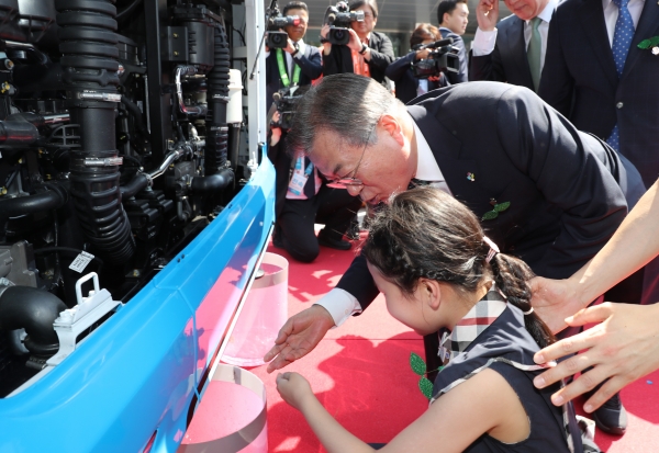 문재인 대통령이 5일 창원컨벤션센터 인근에서 수소버스 제막식 후 어린이와 함께 동력장치를 살펴보고 있다. / 사진=연합뉴스