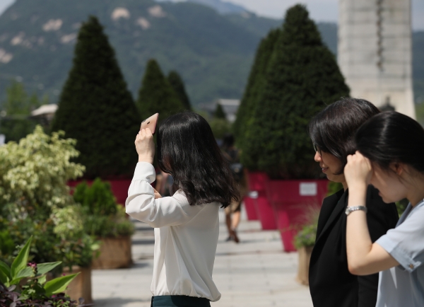 서울 광화문사거리에서 시민들이 휴대전화나 손으로 햇빛을 가린 채 걷고 있다. /사진=연합뉴스