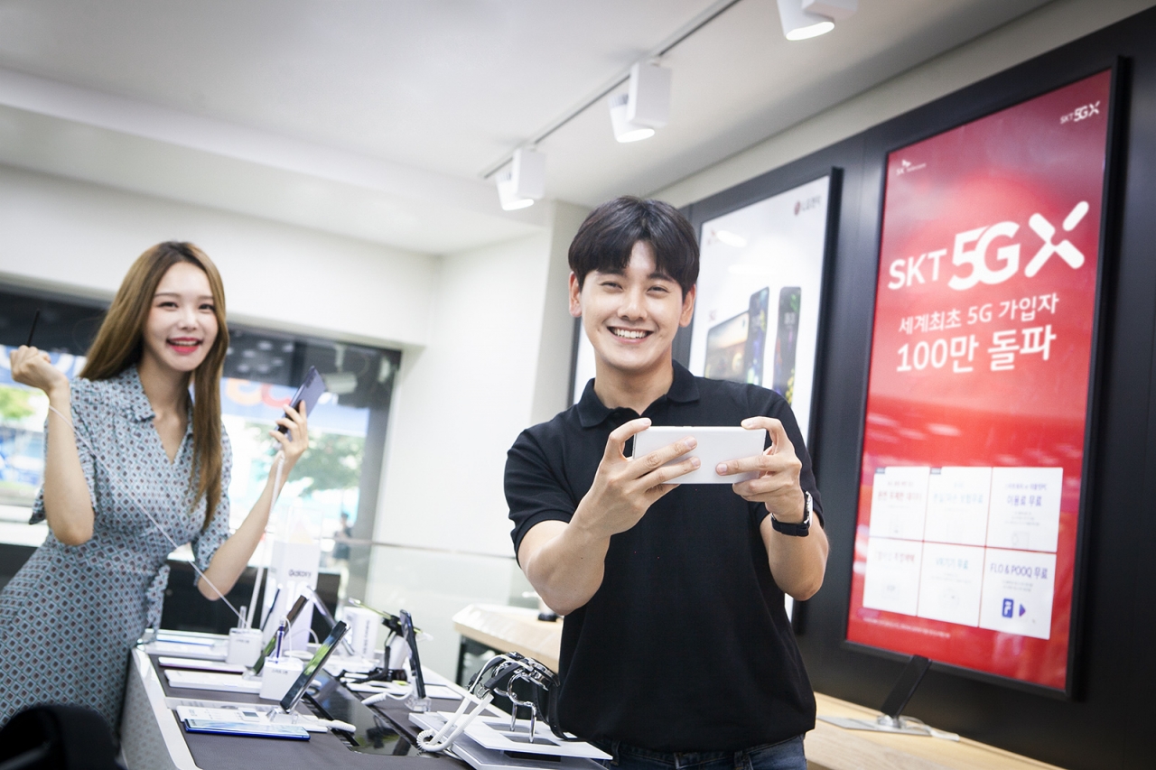 SK텔레콤은 세계 최초로 단일 통신사 기준 5G 가입자 100만 명을 지난 21일 돌파했다고 22일 밝혔다. SK텔레콤 모델들이 서울 명동에 위치한 대리점에서 ‘갤럭시 노트10’로 5G 서비스를 사용하고 있는 모습. / 사진=SK텔레콤