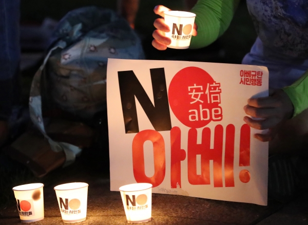 지난 24일 오후 서울 광화문광장에서 열린 아베 규탄 6차 촛불문화제에서 한 참가자가 아베 정부를 규탄하는 촛불과 팻말을 들고 일본 아베를 규탄 하고 있다. / 사진=연합뉴스