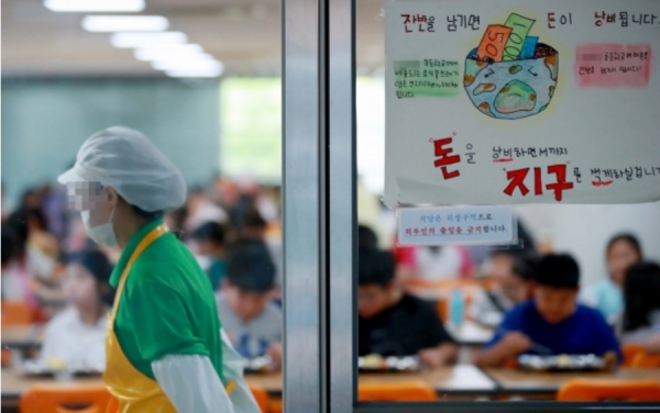 지난 7월 8일 서울의 한 초등학교에서 점심시간 학생들과 학교 조리 노동자의 모습. / 사진=연합뉴스
