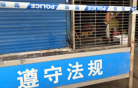21일 중국 후베이성 우한시의 화난수산물도매시장 앞에 경찰 통제선이 설치돼 있다. 한 상인이 당국 허가를 받아 자신 가게에 잠시 들어가 놓고 나온 물건을 챙기고 있다. / 사진=연합뉴스