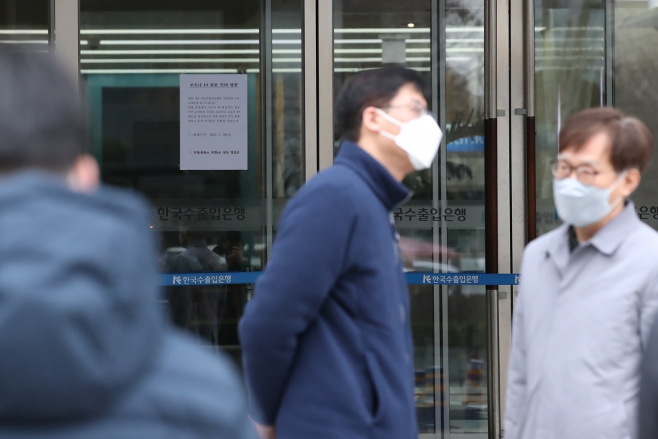 지난달 28일 서울 영등포구 여의도 수출입은행 본점 앞에서 은행 관계자가 마스크를 착용한 채 대화를 하고 있다. / 사진-=연합뉴스