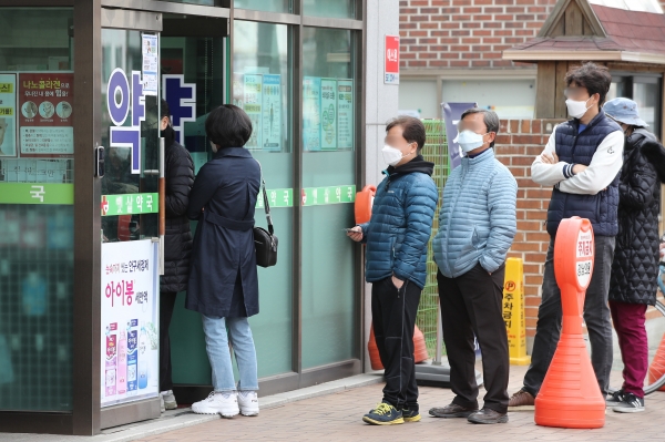 지난 21일 오전 서울 종로구의 한 약국 앞에서 시민들이 공적 마스크를 사기 위해 줄을 서고 있다. / 사진=연합뉴스