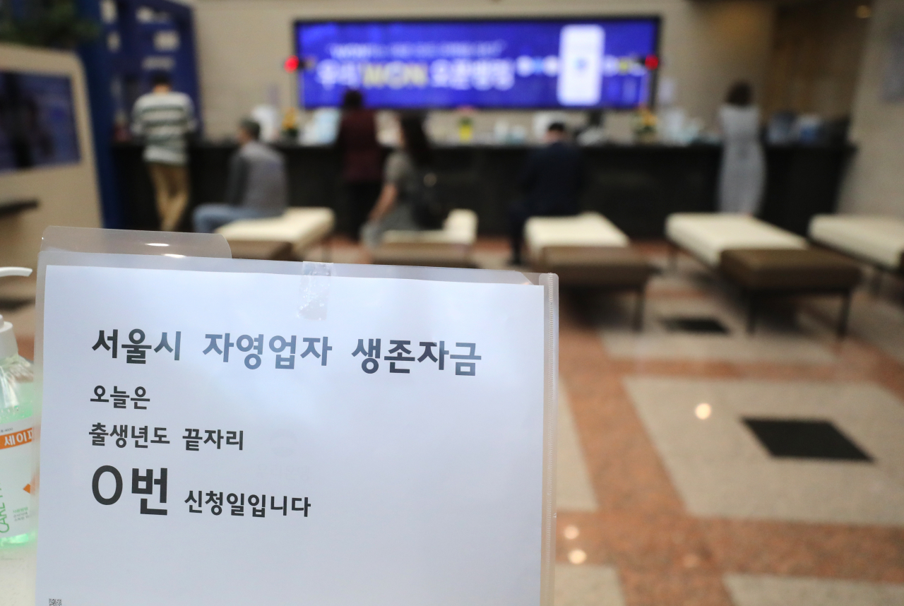 지난 15일 서울 우리은행 본점 영업창구에 '서울시 생존자금' 접수 안내 문구가 놓여 있다. / 사진=연합뉴스