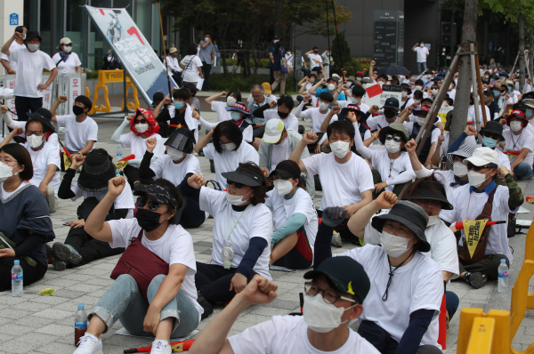 지난 20일 서울 송파구 쿠팡 본사 앞에서 비정규직 노동자 단체와 시민사회단체 등이 모인 '코로나19 비정규직 긴급행동'이 개최한 기자회견에서 참가자들이 코로나19 사태 속에 비정규직 노동자들이 해고와 죽음으로 내몰리고 있다며 대책을 촉구하는 구호를 외치고 있다. / 사진=연합뉴스