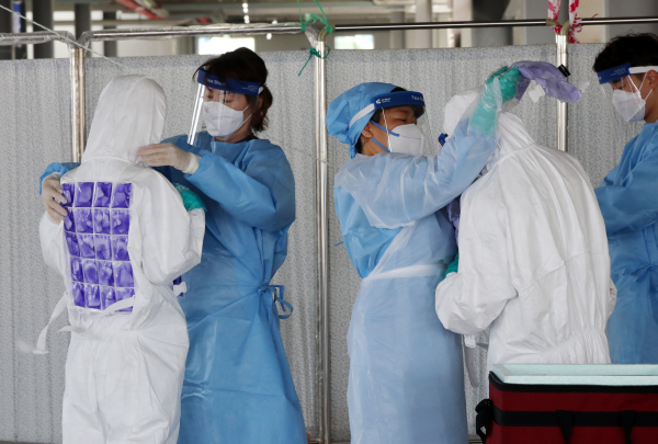 지난 8일 오전 광주 북구 선별진료소에서 보건소 직원들이 무더위가 기승을 부리자 얼음조끼(냉 조끼)를 착용하고 있다. / 사진=연합뉴스