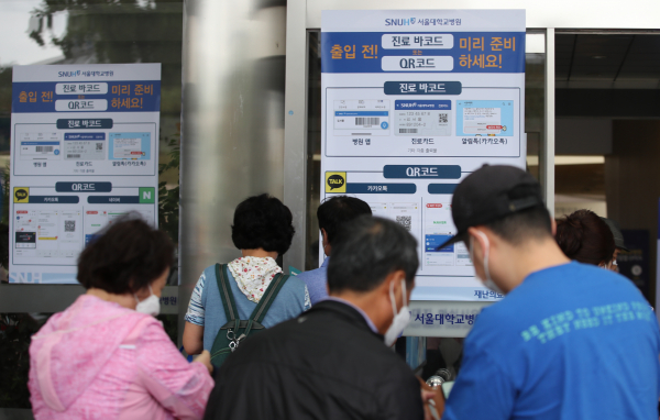 서울대병원이 환자를 포함한 전체 출입객에 개인 신상 정보가 담긴 'QR코드' 발급과 제시를 의무화했다. 19일 서울 종로구 서울대병원 본관에 관련 안내문이 붙어 있다. / 사진=연합뉴스