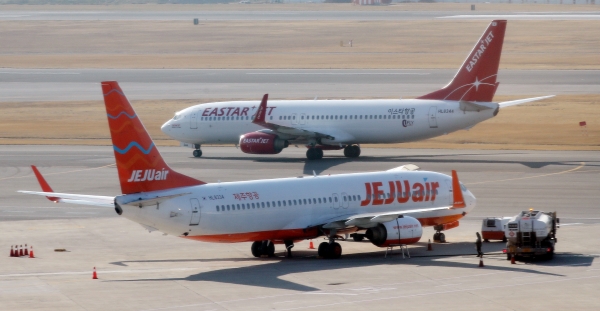 19일 오전 서울 강서구 김포공항에 대기중인 제주항공과 이스타항공 여객기. 제주항공은 전날 이스타항공 최대주주 이스타홀딩스와 주식매매계약에 대한 양해각서(MOU)를 맺고 이스타항공 경영권 인수 절차에 돌입했다. / 사진=연합뉴스