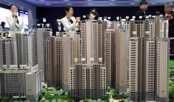 분양을 진행중인 한 사업장 견본주택을 겪은 수요자가 주택 모형도를 보며 분양관계자에게 단지 정보를 설명듣고 있다. / 사진=연합뉴스