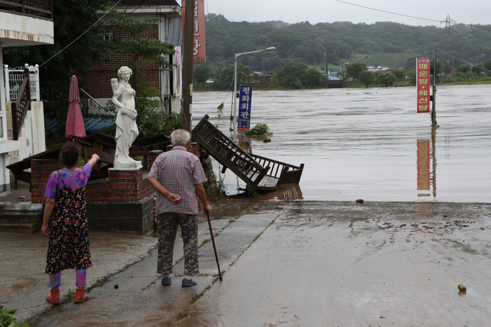 6일 경기도 연천군 임진강변에서 주민들이 불어난 물에 침수된 식당과 상점들을 바라보고 있다. / 사진=연합뉴스