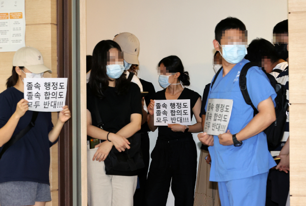 4일 서울 회현동 한국건강증진개발원에서 열린 정부 여당과 의료계의 공공의료 확충 정책 관련 협상 서명식장 앞에서 전공의들이 졸속 합의에 반대하며 피켓시위를 벌이고 있다. / 사진=연합뉴스