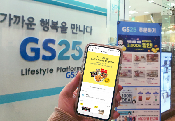 GS25 매장 앞에서 휴대폰을 통해 카카오톡 주문하기 100원딜 이벤트를 살표보고 있다. / 사진=GS25