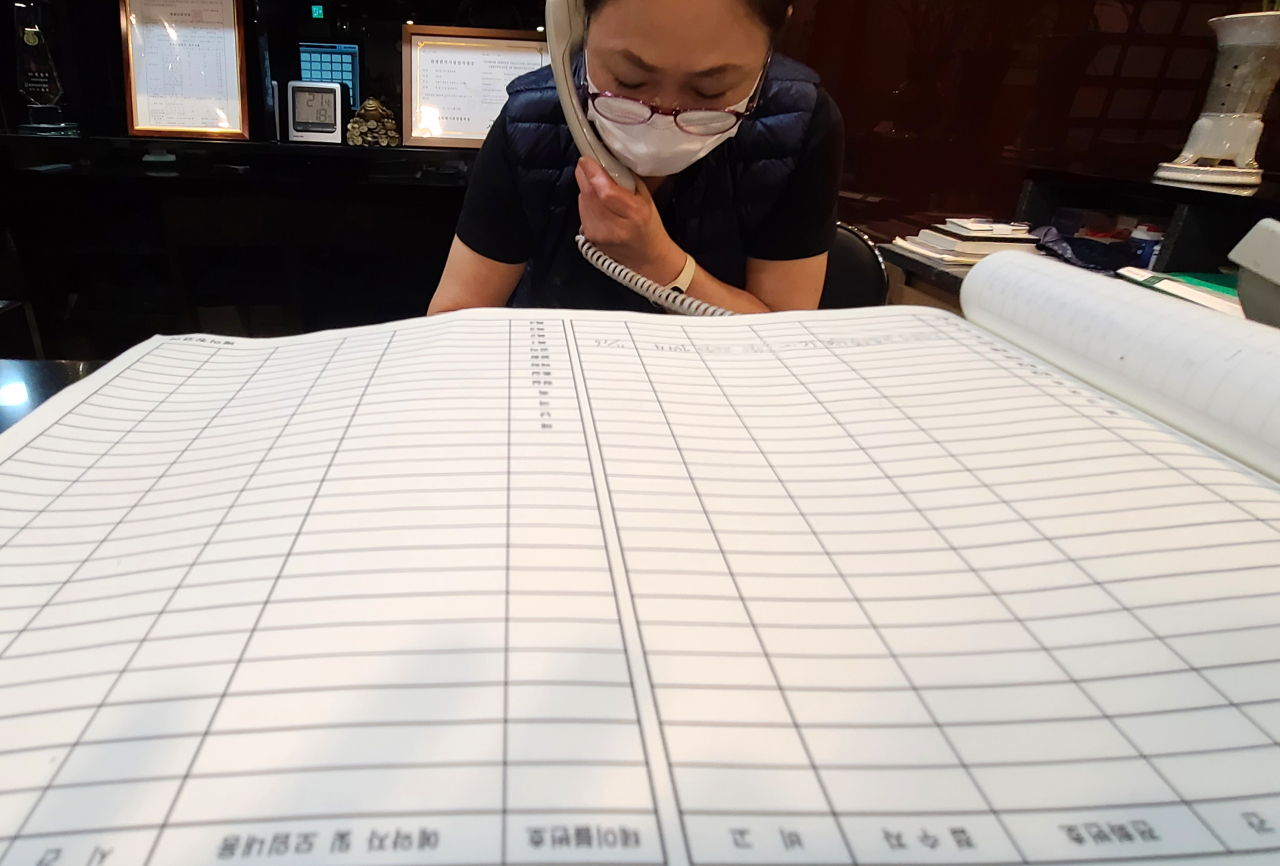 지난 22일 서울 종로구 한 음식점에서 관계자가 연말 모임과 관련한 예약 취소 전화 통화를 하고 있다. / 사진=연합뉴스