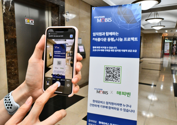 현대모비스 직원이 모바일 QR코드 방식으로 코로나19 피해 극복을 위한 자발적 기부 캠페인에 참여하고 있다. / 사진=현대모비스