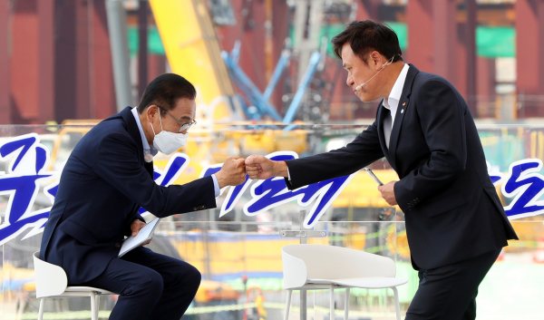 박정호 SK하이닉스 부회장(오른쪽)이 13일 오후 경기 평택시 삼성전자 평택단지 3라인 건설현장에 마련된 야외무대에서 열린 'K-반도체 전략 보고에 참석해 '용인 클러스터 중심 메모리 파운드리 투자 확대계획'을 발표하고 자리로 돌아오며 김기남 삼성전자 부회장과 주먹인사를 하고있다. /사진=연합뉴스