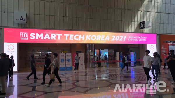 [사진=이현재 인턴] 23일 제1회디지털유통대전이 개막했다. 사람들이 입장하기 위해 입장권 및 관계자 배지를 받고 있다.