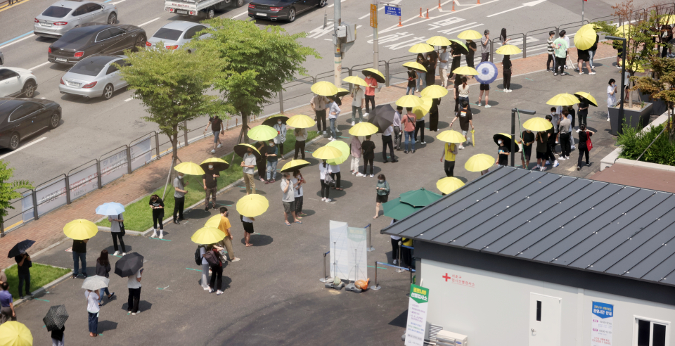 지난 2일 오후 서울 서초구 고속버스터미널 앞 코로나19 선별검사소에서 시민들이 서초구청이 제공한 우산을 쓰고 검사 대기를 하고 있다./사진=연합뉴스