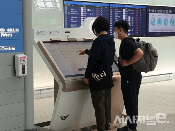 7일 11시경 자녀와 함께 서비스가 추가된 인천공항 키오스크를 이용하는 40대 여성 방문객. 화상서비스를 시도했으나 연결되지 않아 음성서비스를 이용하는 모습이다. 음성서비스를 시도한 그는 이후 터치 서비스를 이용했다 / 사진=이현재인턴기자