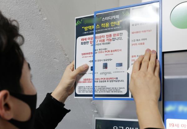 법원이 학원 및 독서실 등 교육시설에 대한 방역패스 효력 정지 결정을 내린 지난 4일 오후 서울 시내의 한 스터디카페에서 관계자가 방역패스 안내문을 제거하고 있다. / 사진=연합뉴스