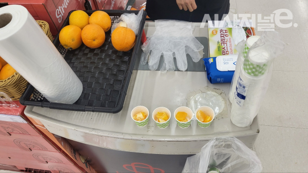 홈플러스 남현점 직원은 오렌지를 시식용기에 담았다. / 사진=한다원 기자