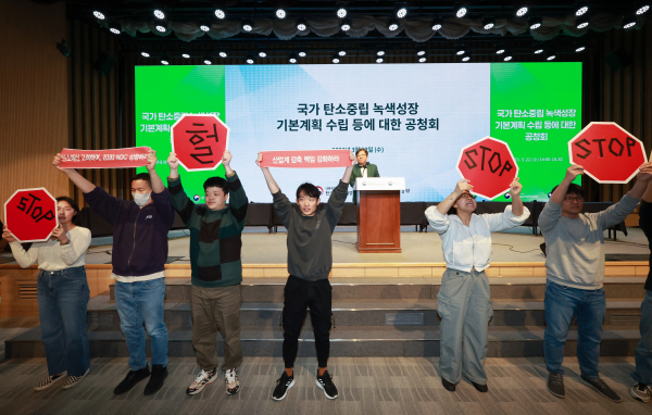 기후위기비상행동을 비롯한 환경단체 회원들이 22일 서울 강남구 한국과학기술회관에서 열린 탄소중립녹색성장위원회와 환경부의 '국가 탄소중립 녹색성장 기본계획 정부안' 첫 공청회에 참석해 김상협 탄소중립녹색성장위원회 민간위원장의 인사말 때 기습 손팻말·펼침막 시위를 벌이고 있다. / 사진=연합뉴스