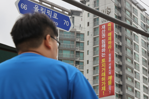 서울시가 이달 22일 지정 기한이 끝나는 강남구와 송파구의 삼성·청담·대치·잠실동에 대해 토지거래허가구역을 1년 연장하기로 했다. 서울 송파구 잠실동에 토지거래허가제 폐지 촉구 현수막이 걸려있는 아파트 모습. / 사진=연합뉴스
