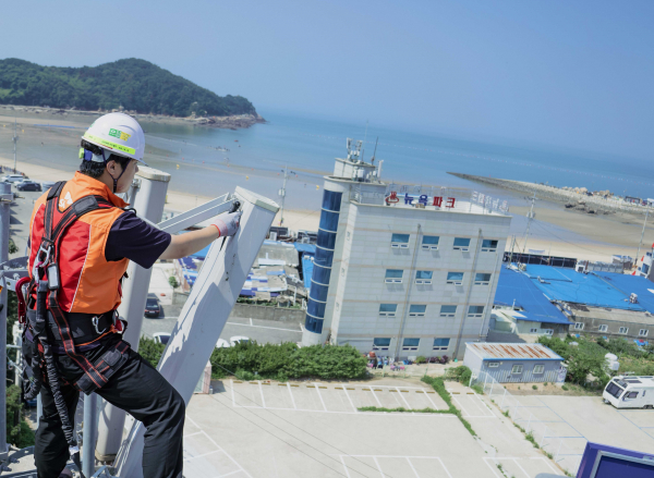 SK텔레콤과 SK오앤에스 담당자가 여름 휴가철 트래픽 증가에 대비해 을왕리 해수욕장 기지국을 사전 점검하고 있다. / 사진 = SK텔레콤