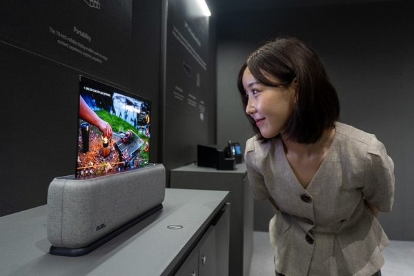 23일 부산 벡스코에서 열린 ‘IMID 2023'에서 관람객이 LG디스플레이의 18인치 차량용 롤러블 OLED 패널을 살펴보고 있다. / 사진=LG디스플레이