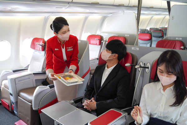 티웨이항공 승무원이 여객에게 서비스를 제공하고 있다. /사진=티웨이항공