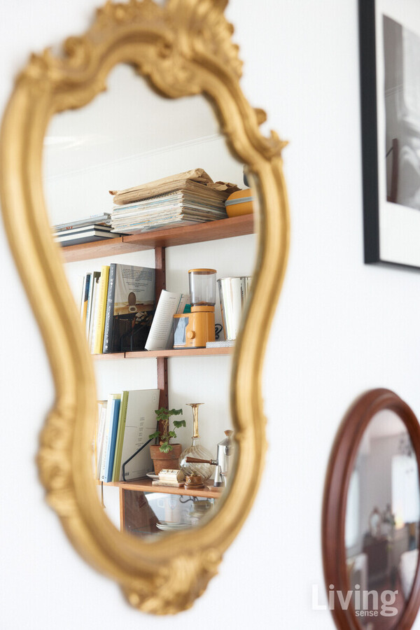거울과 액자로 장식한 벽면.