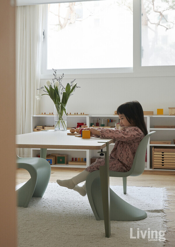 올해 다섯 살이 된 귀여운 딸아이가 파스텔톤의 비트라vitra.com 팬톤체어에 앉아 있다.