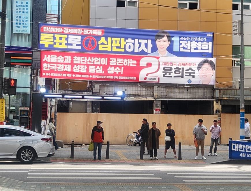 8일 지하철 2호선 성수역 인근에 전현희 더불어민주당 후보와 윤희숙 국민의힘 후보 현수막이 나란히 걸려있다. / 사진=최성근 기자