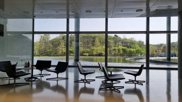 한국테크노돔 1층 회의공간에서 통유리를 통해 바라본 바깥 풍경. 건물 기둥 주위로 물이 고여 있어 환경친화적인 분위기를 연출한다. / 사진=최동훈 기자