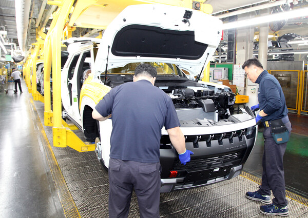 KG모빌리티 조립3공장의 생산직 직원들이 토레스의 엔진룸 구성 작업을 수행하고 있다. / 사진=KG모빌리티