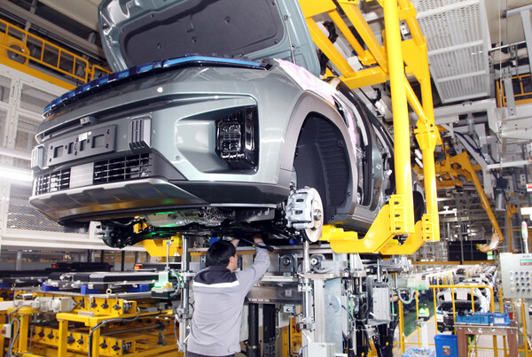 KG모빌리티 생산직 직원이 토레스 EVX의 하부 조립 작업을 진행하고 있다. / 사진=KG모빌리티