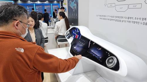 방문객이 LG의 차량 인포테인먼트 시스템을 소개하는 전시물을 살펴보고 있다. / 사진=최동훈 기자