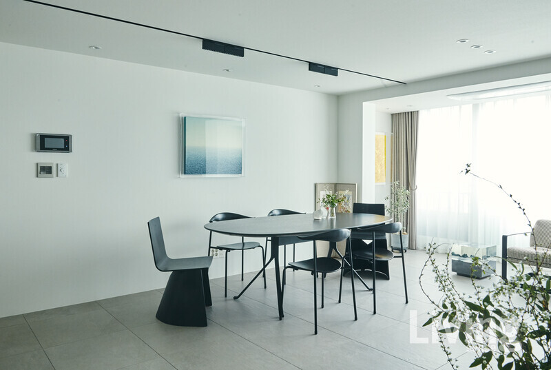 거실에 놓인 라운드 테이블은 유앤어스youandus.co.kr에서 제작한 것.가족이 모여 식사를 하고 대화를 나누는공간으로 가장 활용도가 높다. 벽면에 걸린작품은 오병욱 작가의 ‘Sea of My Mind’.