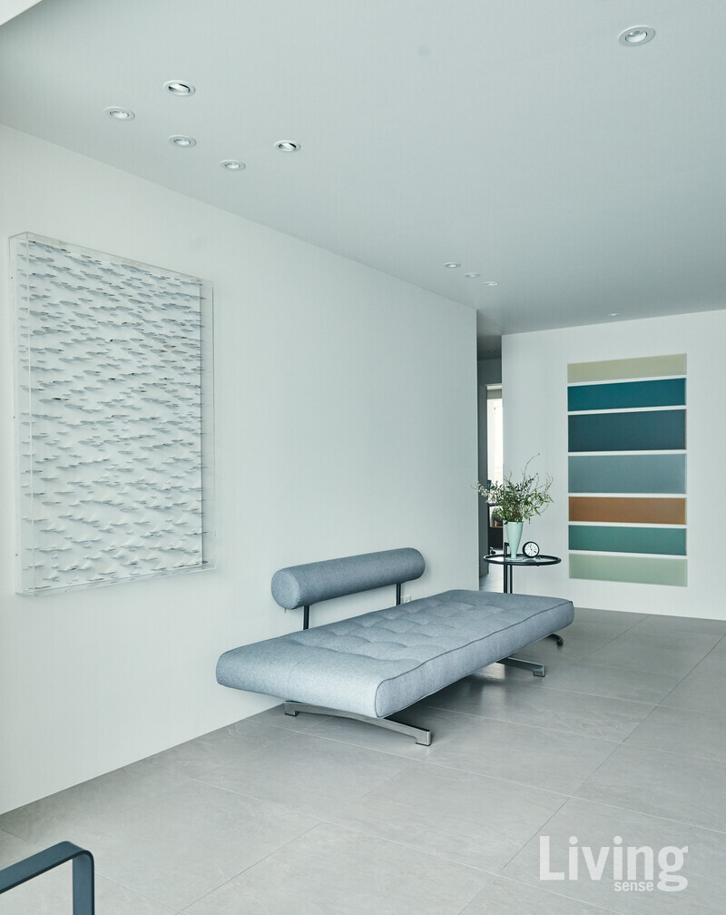 테이블과 면한 거실. 데이베드와 작품으로 간결하게 스타일링했다. 작품은 왼쪽부터 권용래 작가의 ‘The Eternal Flame’, 윤종주 작가의 ‘cherish the time-line’.