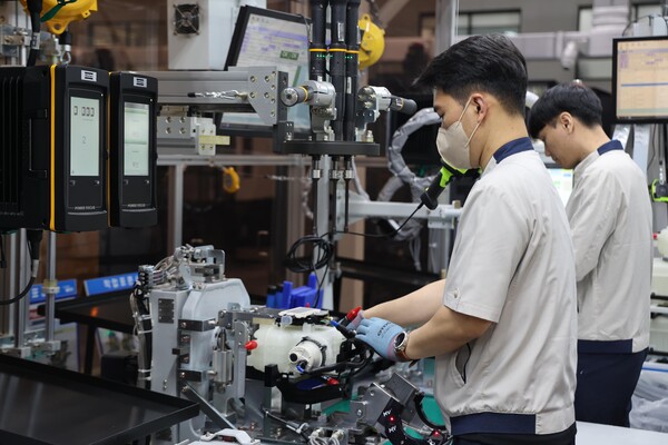 현대위아 창원1공장 직원이 냉각수 허브 모듈을 다루고 있다. / 사진=현대위아