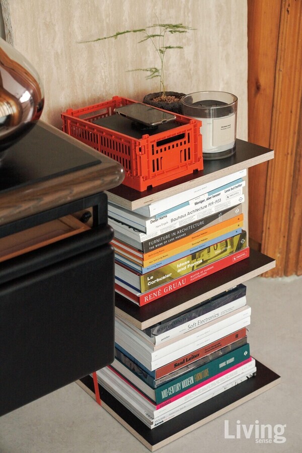 주황색 화물 고정 벨트와 자작나무 합판을 활용해 디자인 서적을 보관할 선반을 직접 만들었다. 