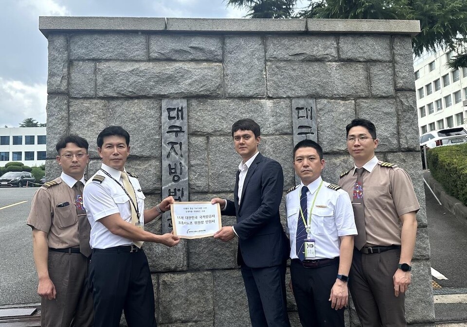 8일 대구지방법원 앞에서 최현 조종사연맹위원장(왼쪽에서 두 번째)이 연맹 집행부와 함께 전대일 대표변호사(법무법인 양우)에게 조종사노조 위원장 11명 전원의 탄원서를 전달하고 있다. / 사진=조종사연맹