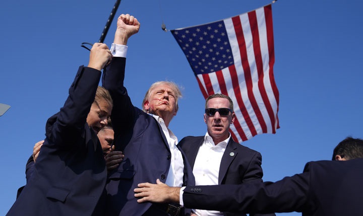 도널드 트럼프 전 미국 대통령이 13일(현지시간) 펜실베니아주 버틀러에서 유세를 벌이던 중 총성 발생으로 연간에 몸을 숙였다가 일어선 모습. / 사진=AP통신