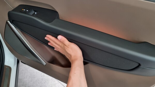 EV9 1열 동승석 도어 트림에 적용된 복사열 난방 시스템의 온도를 체험하고 있다. 이 시스템은 신체가 닿는 것이 느껴지면 온도를 낮춰 화상 위험을 줄인다. / 사진=최동훈 기자