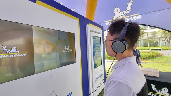 천막 안에 마련된 헤드셋을 끼고 미쉐린 타이어가 장착된 전기차의 실내 소음을 청취하고 있다. / 사진=최동훈 기자