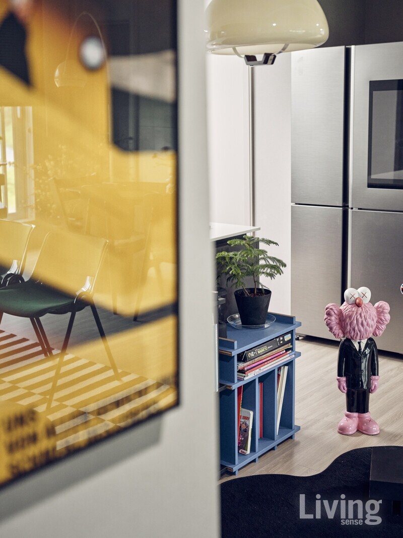 노란 포스터 너머로 아들 로아가 이 집에서 제일 좋아하는  공간이 보인다. 책장에는 그림책이 가득 꽂혀 있다.