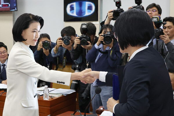 이진숙 방송통신위원장이 7일 오후 국회 과학기술정보방송통신위원회의 국정감사에서 최민희 위원장에게 증인선서문을 전달 후 악수하고 있다. 이 위원장은 야당이 단독 처리한 탄핵소추로 직무가 정지된 상태라 기관 증인이 아닌 일반 증인으로 출석했다. / 사진 = 연합뉴스